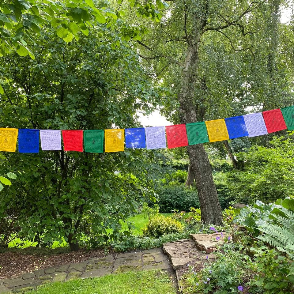 Tibetische Gebetsfahnen im Garten - bunte Wimpelkette aus Baumwolle