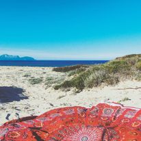 Rundes Strandtuch rot gelb unterwegs im Urlaub