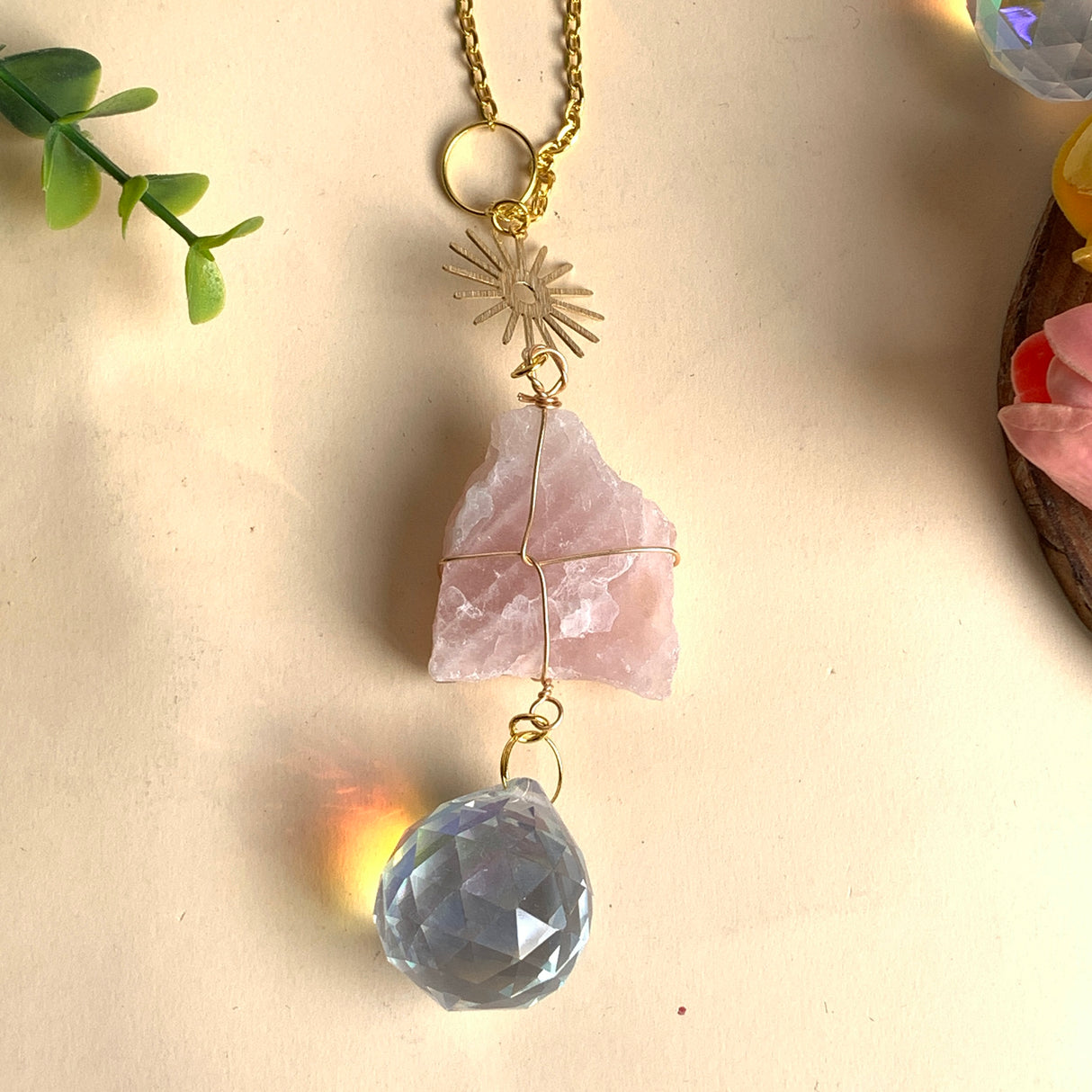 Sonnenfänger Rohstein Rosenquarz, goldene Sonne und facettierte Kristallkugel für sanfte Regenbogen Lichtspiele am Fenster