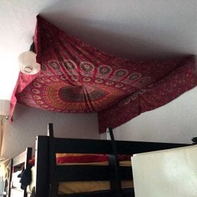 Beispiel Pfauenfeder Mandala in rot weiß über dem Bett